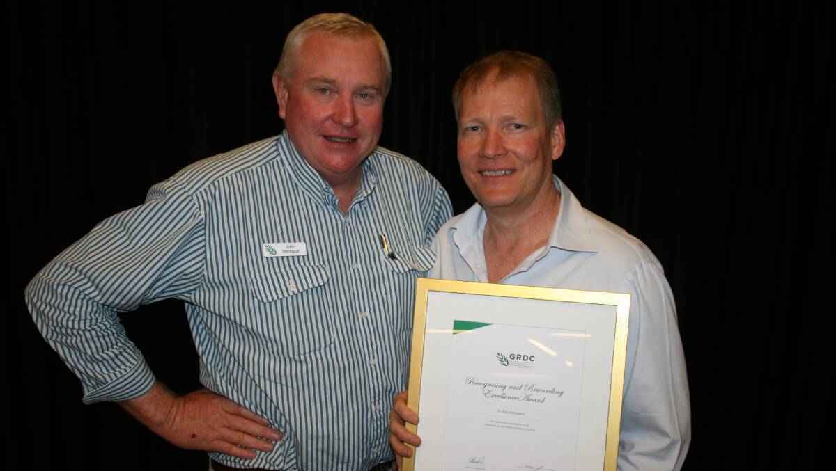 Grains Research and Development Corporation (GRDC), northern panel chair, John Minogue presents CSIRO chief research scientist, Dr John Kirkegaard with the GRDC Recognising and Rewarding Excellence Award during the GRDC update dinner in Dubbo.