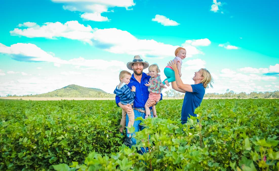 Rohan and Suzie Hindle with children Tom, Madalene, and Ella in the family's irrigated cotton crop at Bungaree, Theodore with recent rainfall boosting harvest expectations.