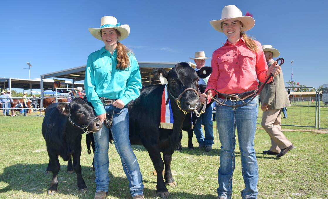 HANDS ON: Charleville State High School students, Natalya Dingle and Renee Duff holding the small breeds champion exhibit, Collinthia Park Lady Helen 2 with her calf, Lucky.