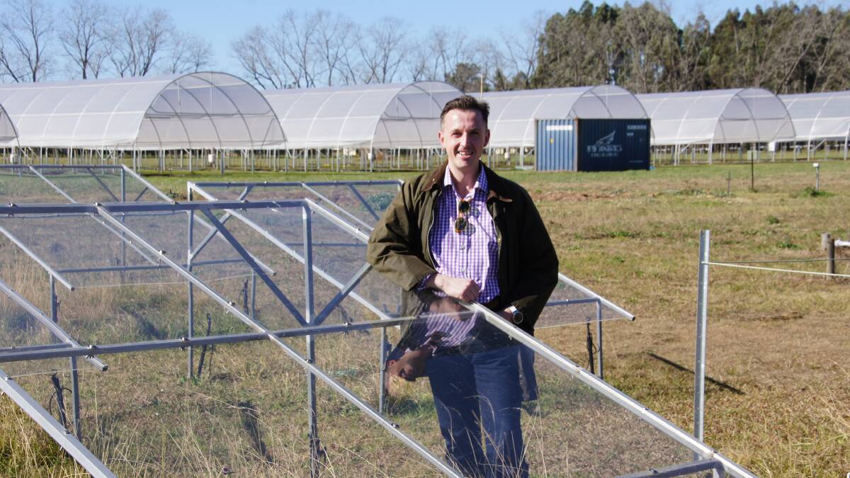 Dr Scott Johnson with a rain exclusion shelter that is being used in early research of silicon and grasses. A variety of shelters are used to deliver pasture a range of rainfall patterns.