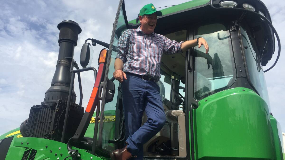 LNP leader Tim Nicholls some to grips with a half-million dollar four-wheel-drive John Deere tractor at Vanderfields in Emerald.