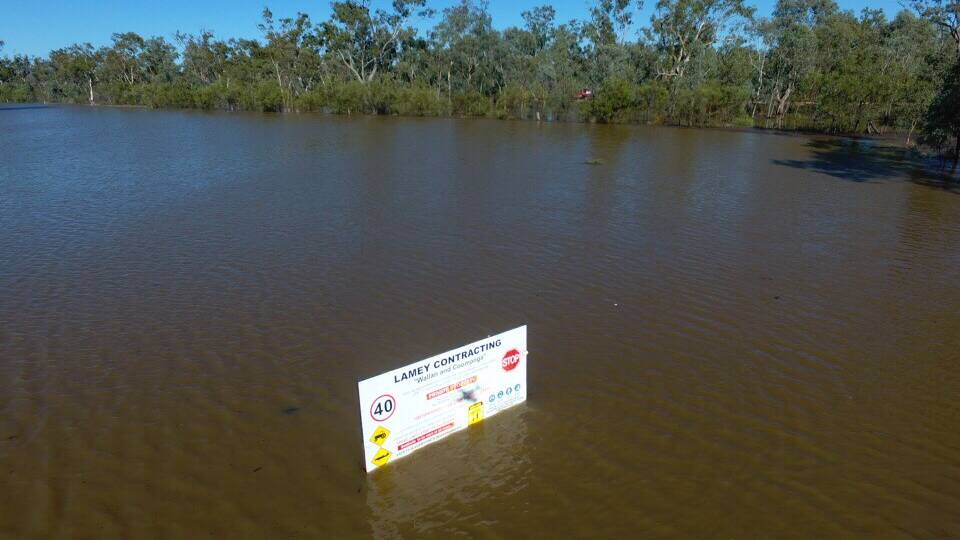Water banked up behind a raised road on the floodplain, blocking access to Coomonga and drowning valuable crops. 