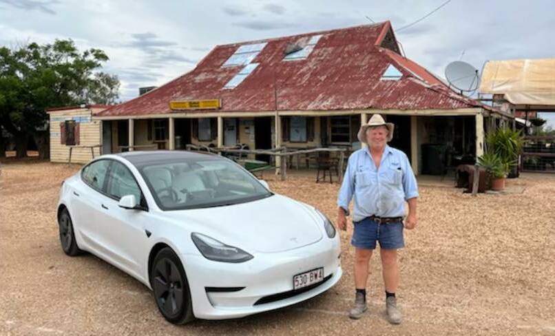 Hebel Hotel owner Frank Deshon pictured outside the pub with a tourist's Tesla. Photo: Supplied