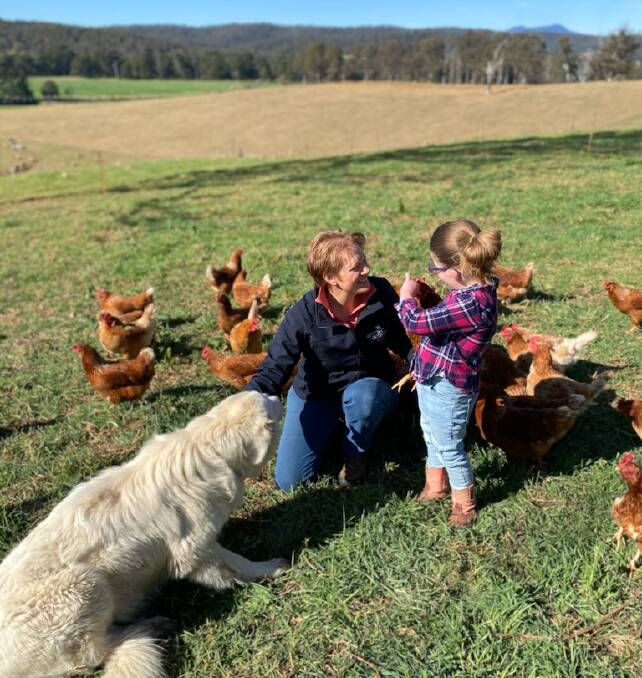 Jo Broad, Lexie Stevens and maremma guard dog Elliie with the chickens that produce Lachie's Farm Fresh Eggs in Bodalla. Picture supplied