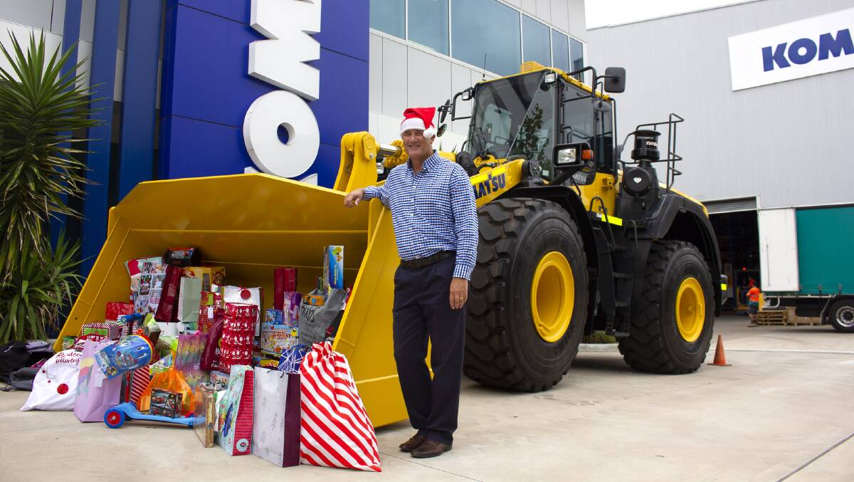 Komatsu, executive general manager, Colin Shaw with the Christmas gifts collected for the Salvation Army to distribute to local children. 