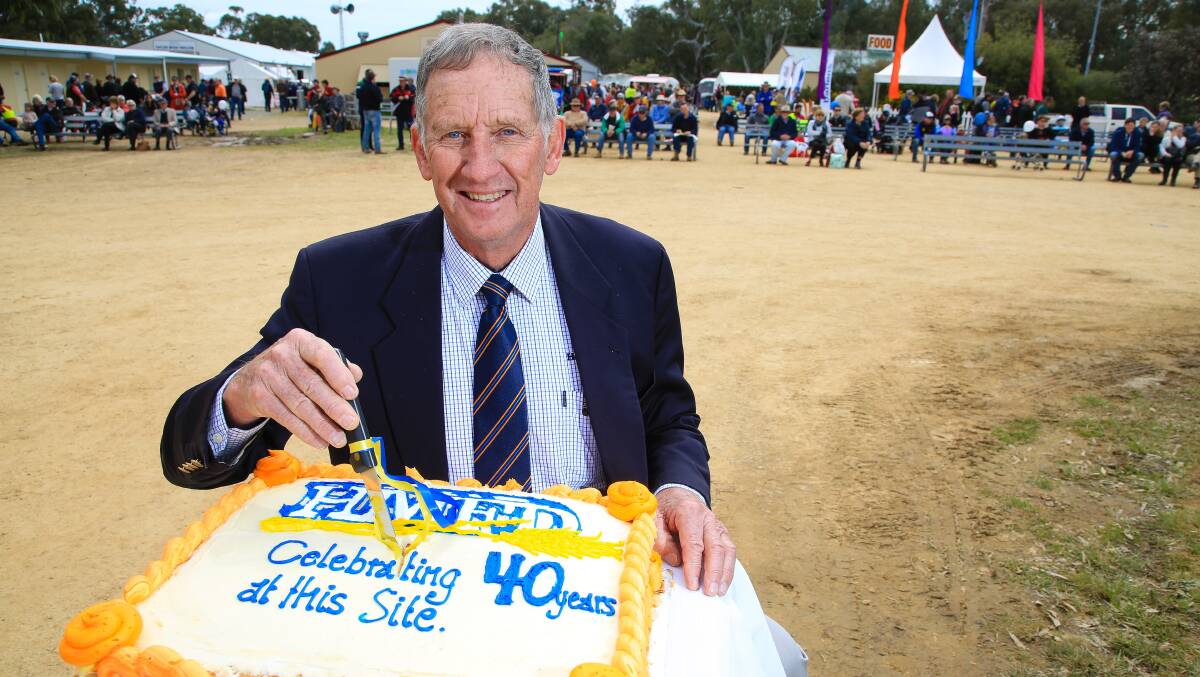 Colin Wood, chairman of the Henty Machinery Field Days for three decades, cuts the 40th anniversary cake at the 2016 event. Photo: Kim Woods