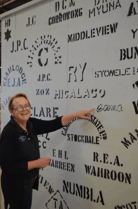 Vicki Flynn admiring the wool bale stencil display, a feature of her workplace in the Cooma woolstore.