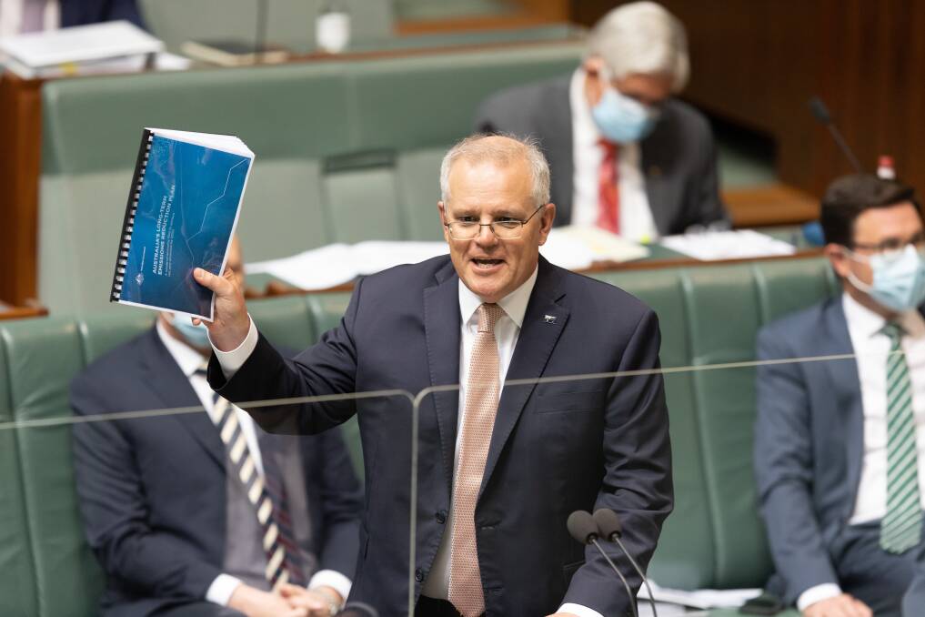 THE PLAN: Prime Minister Scott Morrison holds up a copy of the 2050 net-zero roadmap in parliament. Photo: Sitthixay Ditthavong