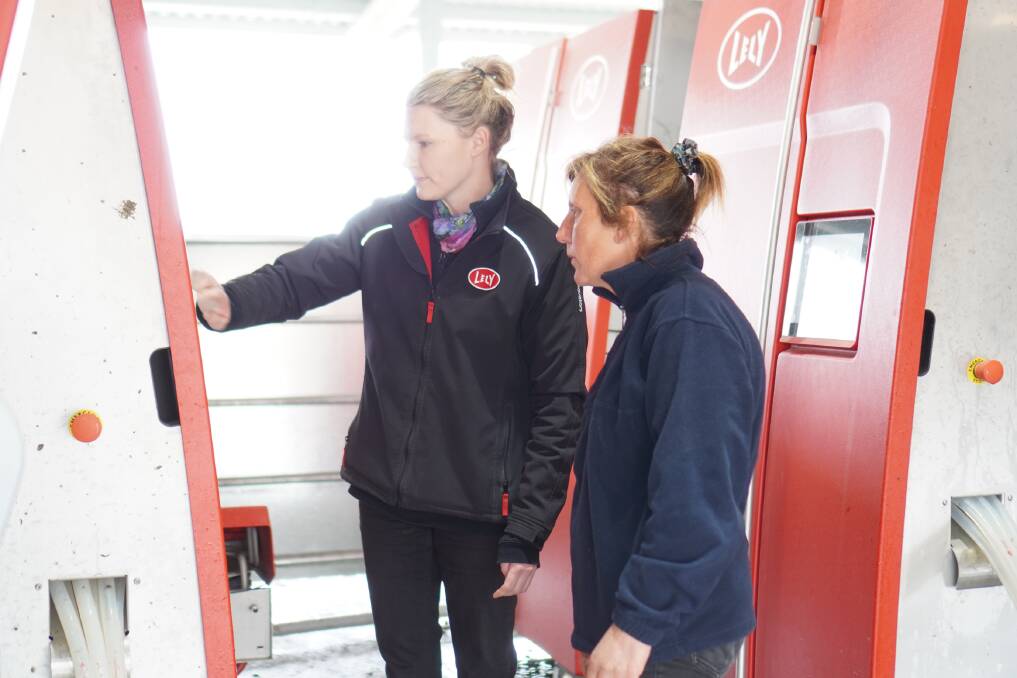 Casey Parker, from Lely, who provides software support to farmers and helps during the commissioning of the robots, and Leesa Williams adjusts robot settings.