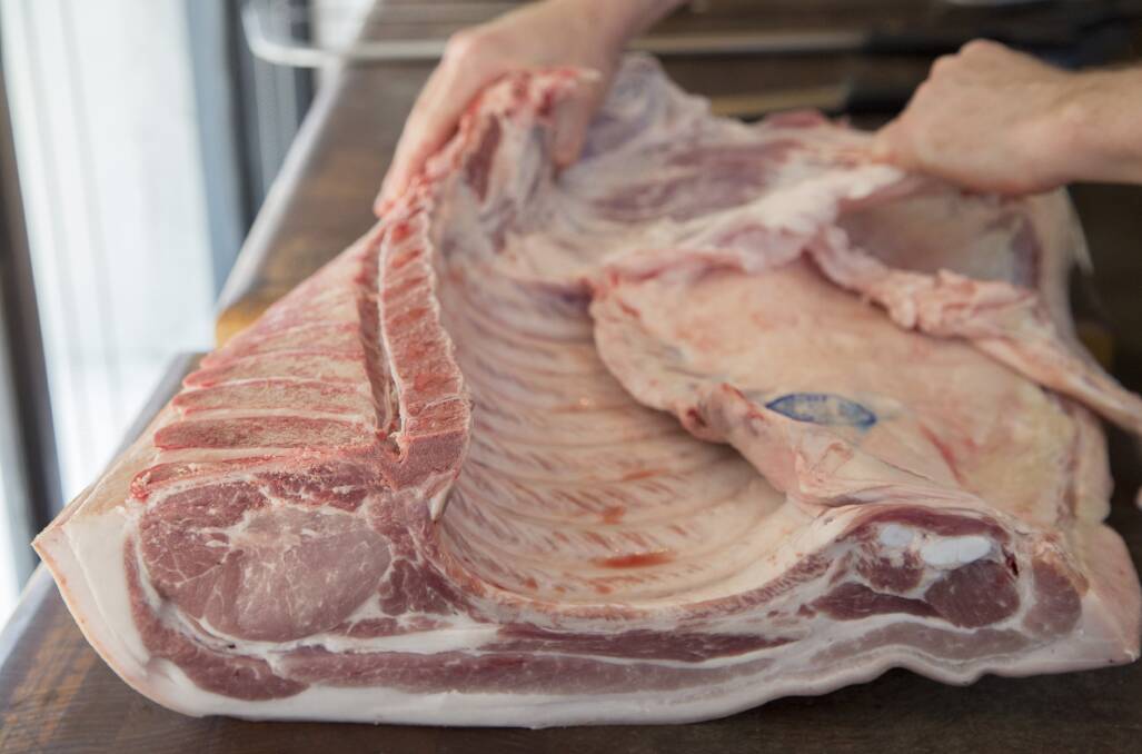A Californian butcher breaks down a pig carcase.