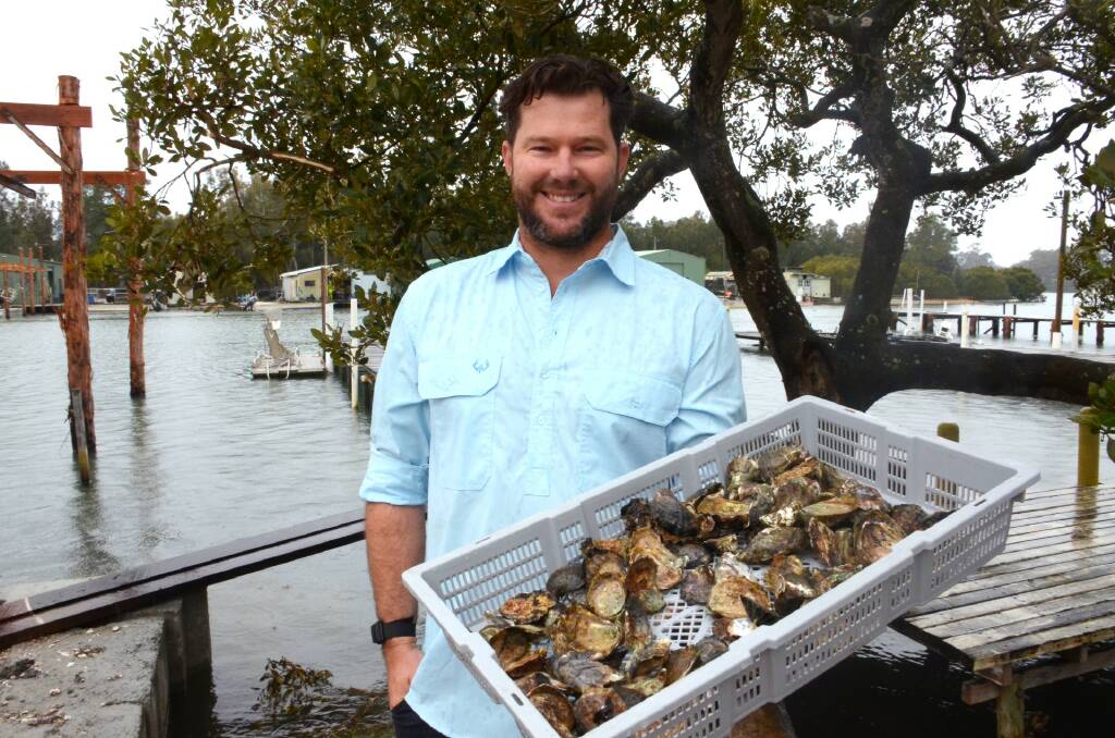 SmartOysters CEO Ewan McAsh holds a basket of Sydney rock oysters at his family farm on the Clyde River, Batemans Bay. Picture: Claudia Ferguson. 