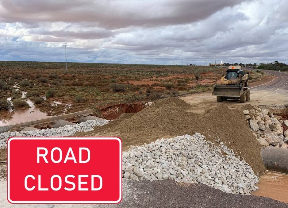 Contractors work on a temporary fix of the washed out Pimba to Woomera road to allow trapped locals and visitors to escape. Picture: Roxby Downs Council. 
