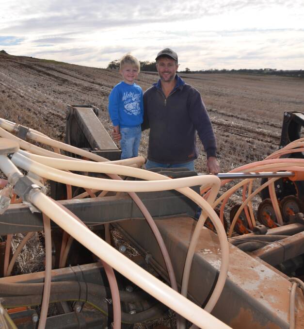 Ngapala farmer Patrick Neal (pictured with three-year-old son Tom) started seeding in mid-April and said 60 millimetres of opening rains had meant early-sown sheep feed and canola was "up and away".
