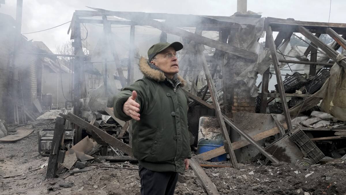 A man opens his arms as he stands near a house destroyed in the Russian artillery shelling, in the village of Horenka close to Kyiv, Ukraine, on Sunday. (AP Photo/Efrem Lukatsky).