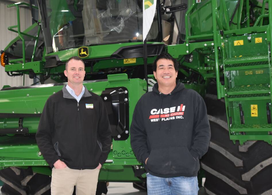 UNITED FRONT: Even old red and green rivalries were put aside at the recent machinery exhibition at the Wimmera Events Centre. James Gardner, Emmetts Machinery, shows Isaac Leffler, Kaniva, the latest X9 header.