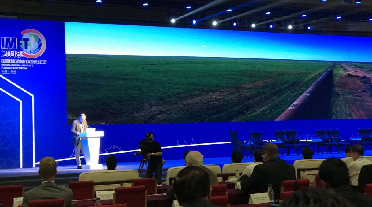 A huge screen amplified the message of western Queensland's natural beauty that was shared by Longreach mayor, Ed Warren, in China recently.