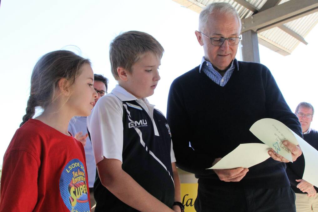 Longreach School of Distance Education students, Jennifer and Thomas Scholes sharing the invitation to the school musical with Malcolm Turnbull at Blackall.