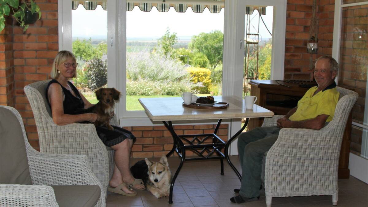 Margaret and Peter, along with their furry friends, enjoy the view from the sunroom east to Toowoomba.