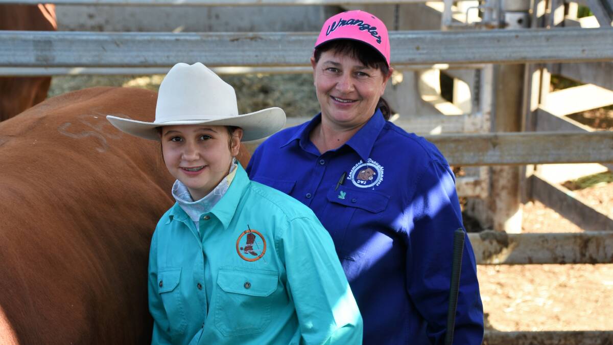 Chloe and her mother Leonie Davey checking their bulls in the pens prior to their sale at CQLX last week. Picture - Sheree Kershaw.