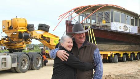 Marisse Kinnon was on hand to give her husband Richard a relieved hug as transport operators began backing the Pride of the Murray down the driveway to the Outback Pioneers' Thomson River tourist site. Pictures: Sally Gall