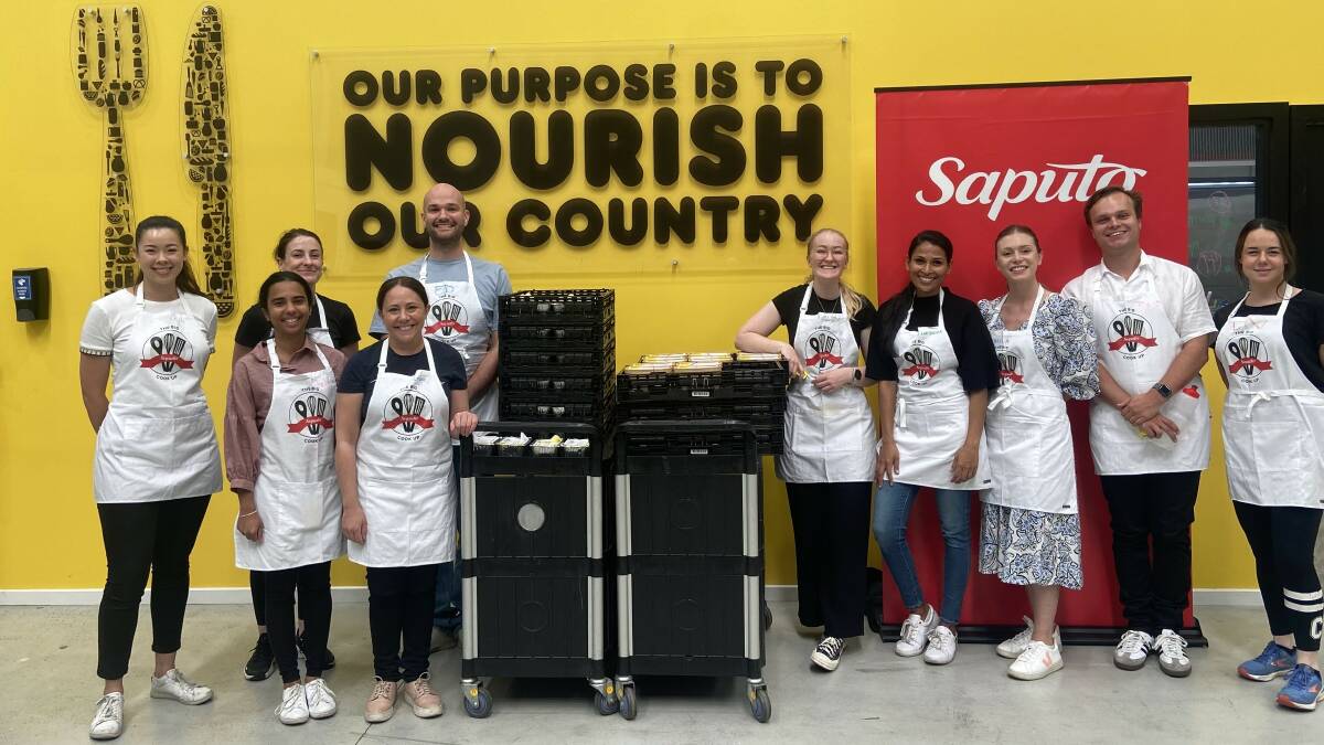 Saputo Dairy Australia team members with meals cooked for communities in need at OzHarvest in Melbourne on March 6. Picture supplied