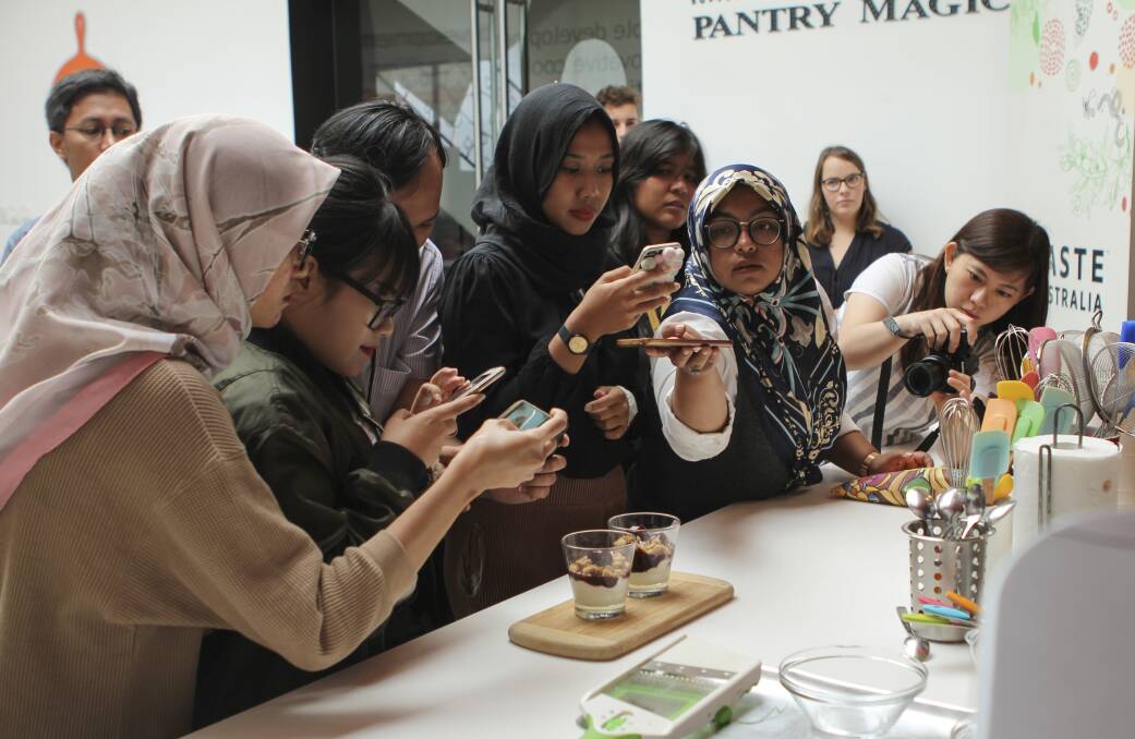 TASTY SNAP: In Indonesia, onlookers make the most of a food photo opportunity as part of the Taste Australia campaign, created by Horticulture Innovation Australia. 