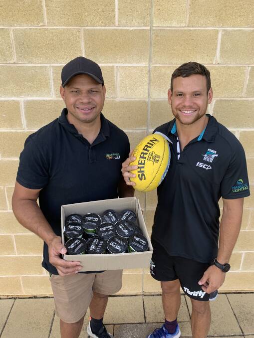 EAT UP: AFL players Daniel Motlop and Danyle Pearce with a swag of the new Fleurieu Milk Company yoghurts.