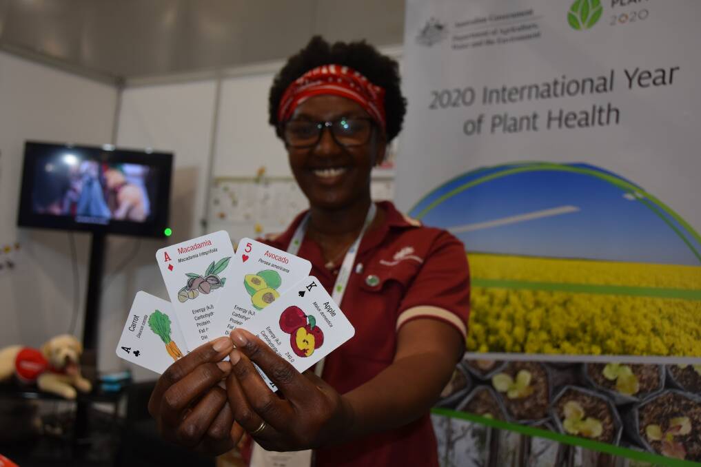 WHEN TO HOLD THEM: Department of Agriculture, Water and the Environment assistant director - international capacity building plant systems and strategies biosecurity plant division, Carol Quashie-Williams, with the fruit, vegetable and nut playing cards which can assist in learning about food nutrition. 