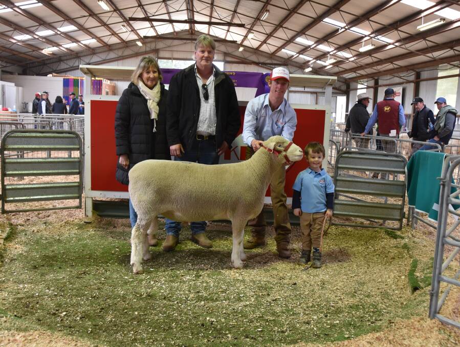 SALE TOPPER: Craig Graham and Deb Stone, Sandilands, South Australia, with their top-priced ram held by James Gilmore with his son, Hudson, 3. 