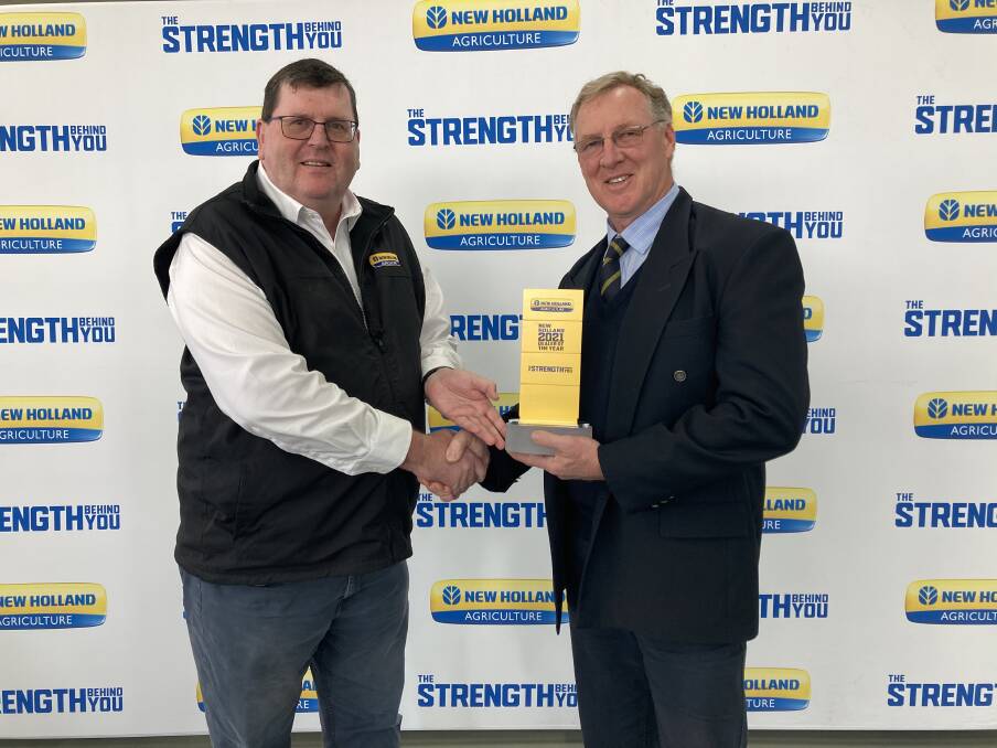 CONGRATULATIONS: New Holland's Bruce Healy hands over the Dealer of the Year award to Peter Russell from On-Trac Ag Bathurst. 