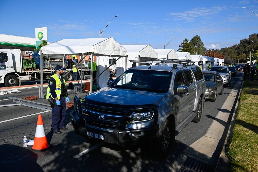 LINE UP PLEASE: Cars proceed through Albury's Wodonga Place check point on Thursday afternoon. Picture: MARK JESSER