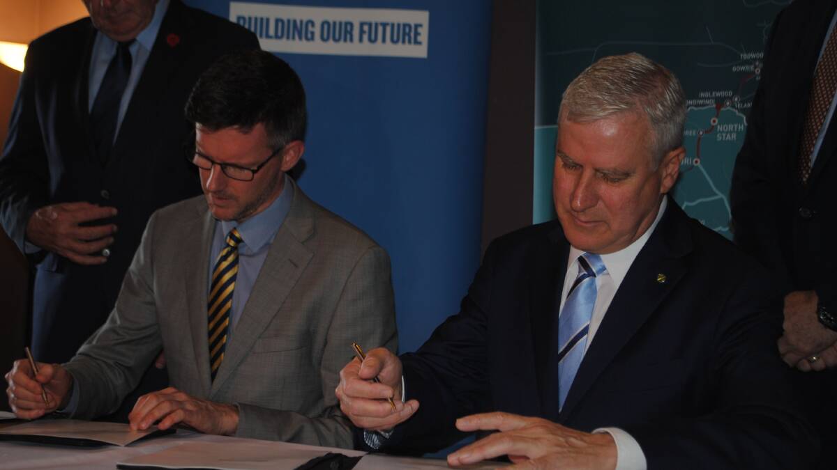 Queensland transport minister Mark Bailey and Deputy Prime Minister Michael McCormack sign the bilateral agreement for the Inland Rail in Toowoomba. 