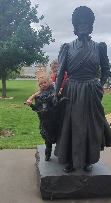 Ben and Lucy Hodgson, grandchildren of John and Vera Taylor, at the Eliza and Ram statue in Campbell Town, Tasmania. 
