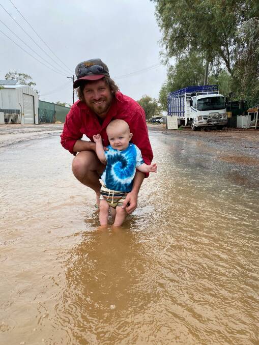Ben Crozier and his son Henry doing what you don't do in Tibooburra too often - playing in a puddle. Photo by Vicki Jackson.