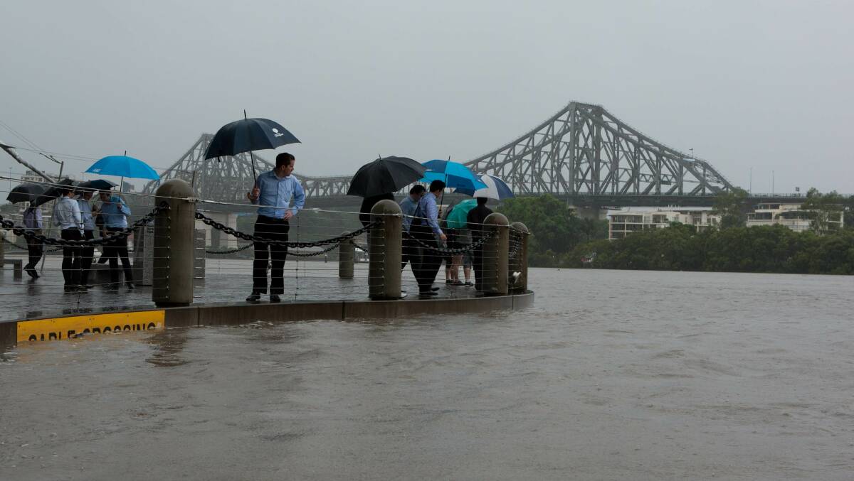 Residents watching the river rise in the Brisbane CBD in 2011. Photo: Paul Harris