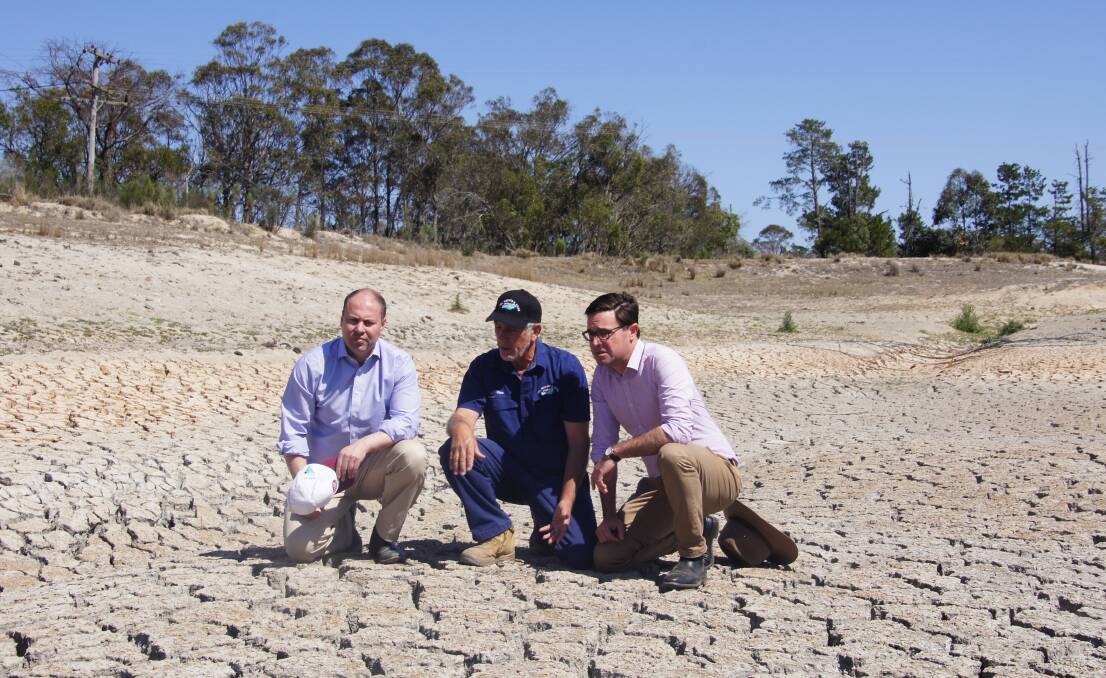Treasurer Josh Frydenberg, apple grower Dino Rizzato, and Drought Minister David Littleproud inspect Mr Rizzato's dam.