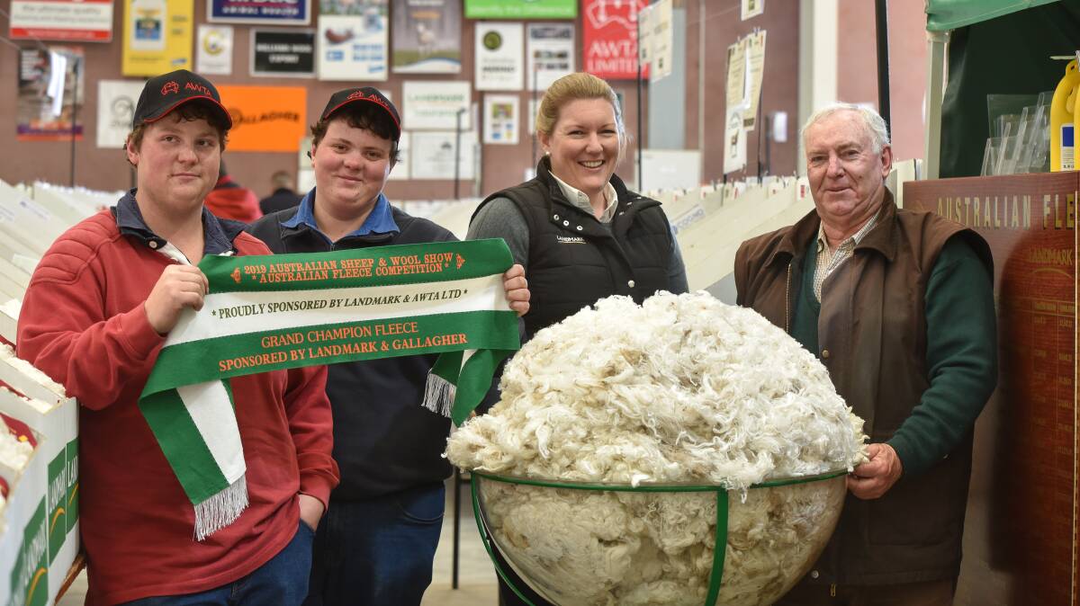 Darren, William and Stephen Glen, Wattle Bank Merino stud, with Australian Fleece Competition convener Candice Cordy, Landmark (second from right), and the champion fleece. Photo by Ruby Canning.