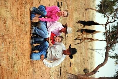 Peter and Cathy White with two of their children, Jessica and Bruce, and three wild dogs Mr White killed and hung up on their property, Athelstane, Winton.
