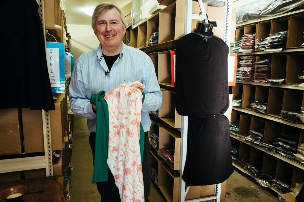 Warwick Rolfe in his storeroom with a Signature Prints scarf.