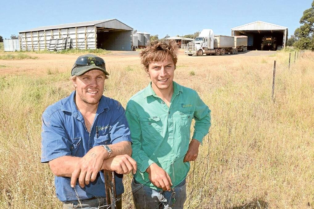 Nathan and Kieran Simpson in front of the grain storage site at “Binginbar”. 