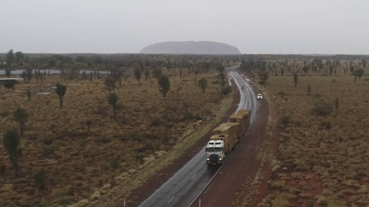 The 70 road trains of hay from Western Australia and South Australia passed by Uluru on their way to drought-declared south-west Queensland. 